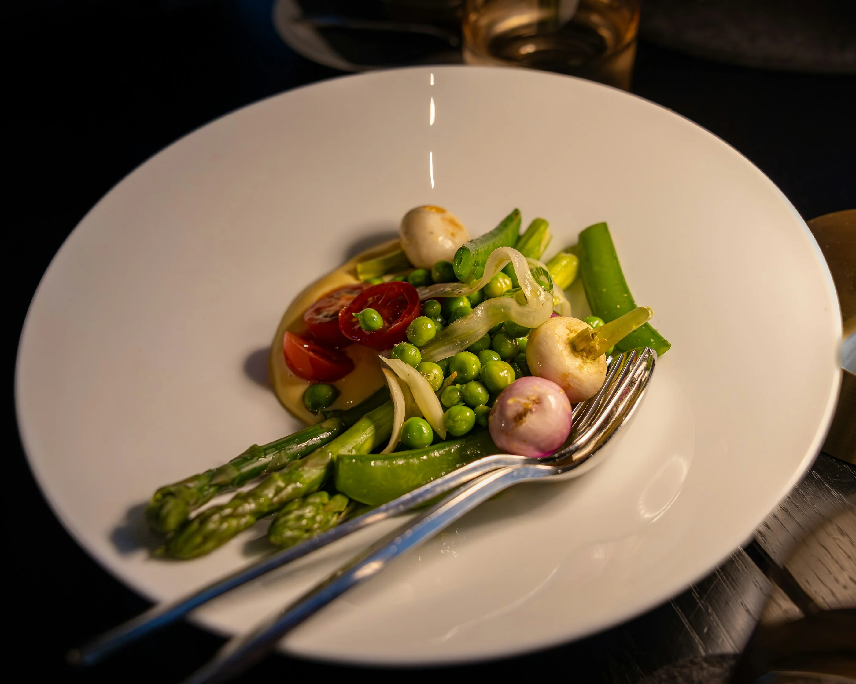 Plato de verduras de temporada con guisantes, espárragos y cebolletas