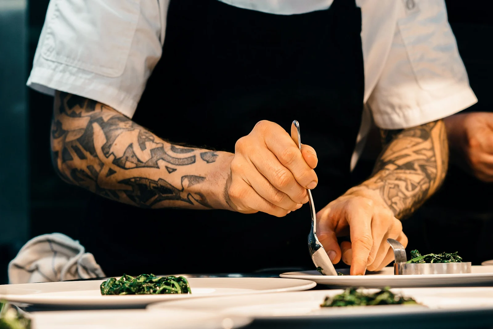 Un cocinero coloca la verdura en el plato