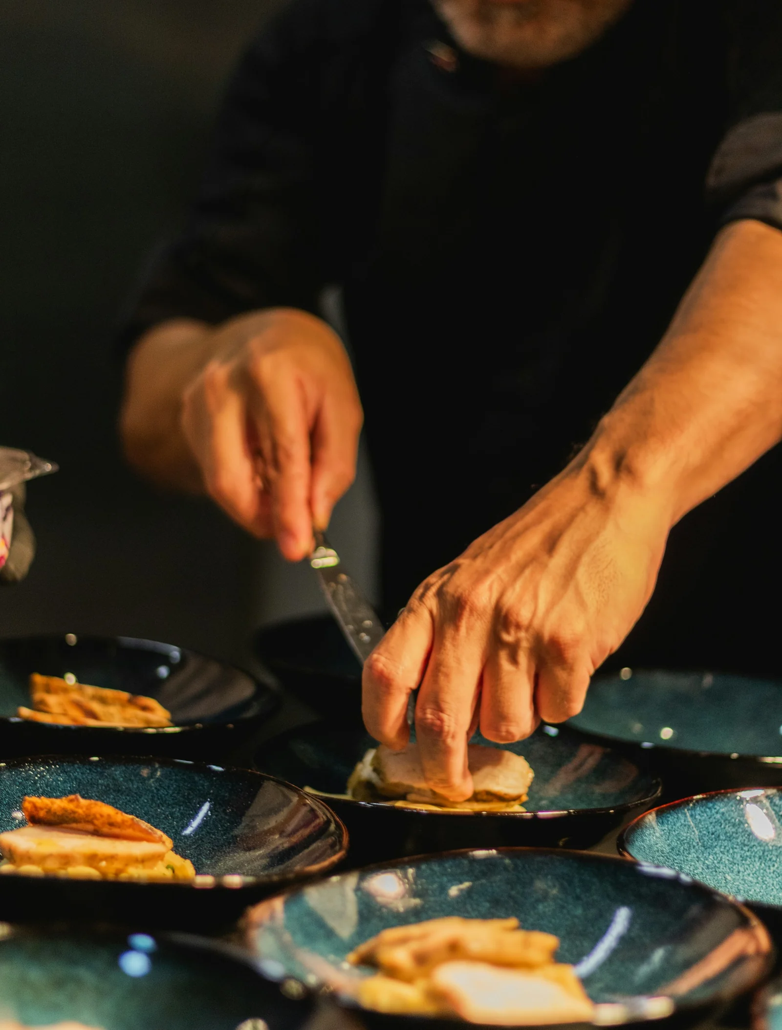 Manos que sirven los platos en la cocina